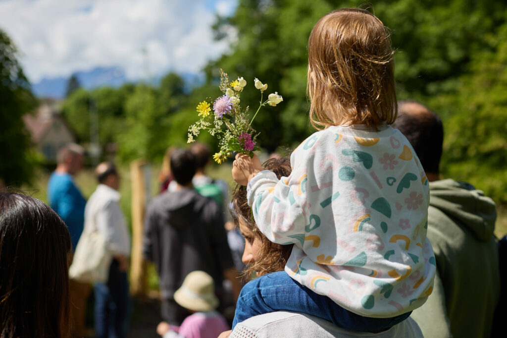 Petite fille qui tient un bouquet de fleurs pendant la Fête de la Nature © Yann André
